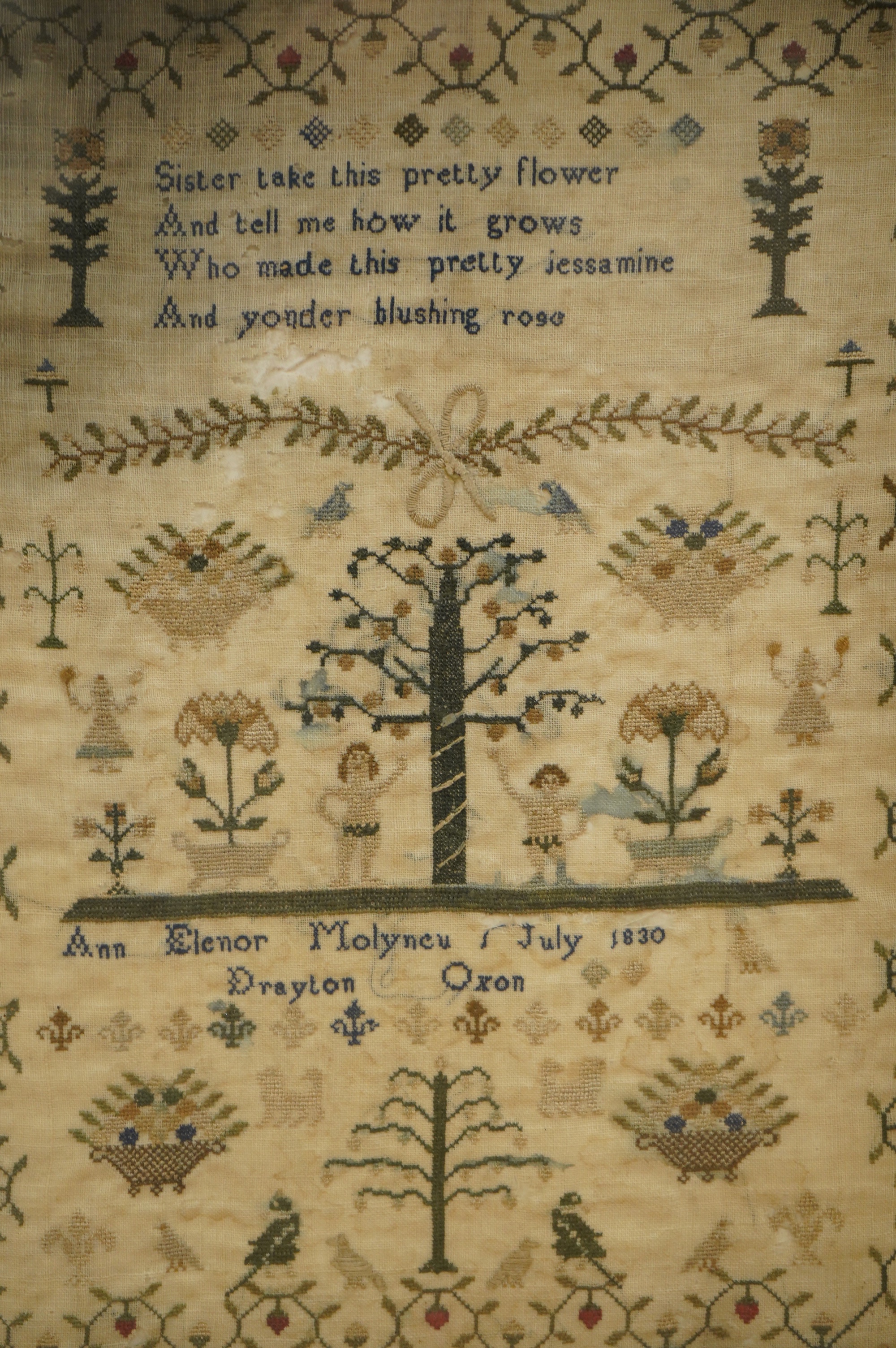 A framed Adam and Eve finely embroidered sampler, by Ann Elenor Molyneu, dated July 1830, Drayton, Oxon, embroidered on fine linen with multi-coloured silks and geometric stylistic floral border, with a short verse above